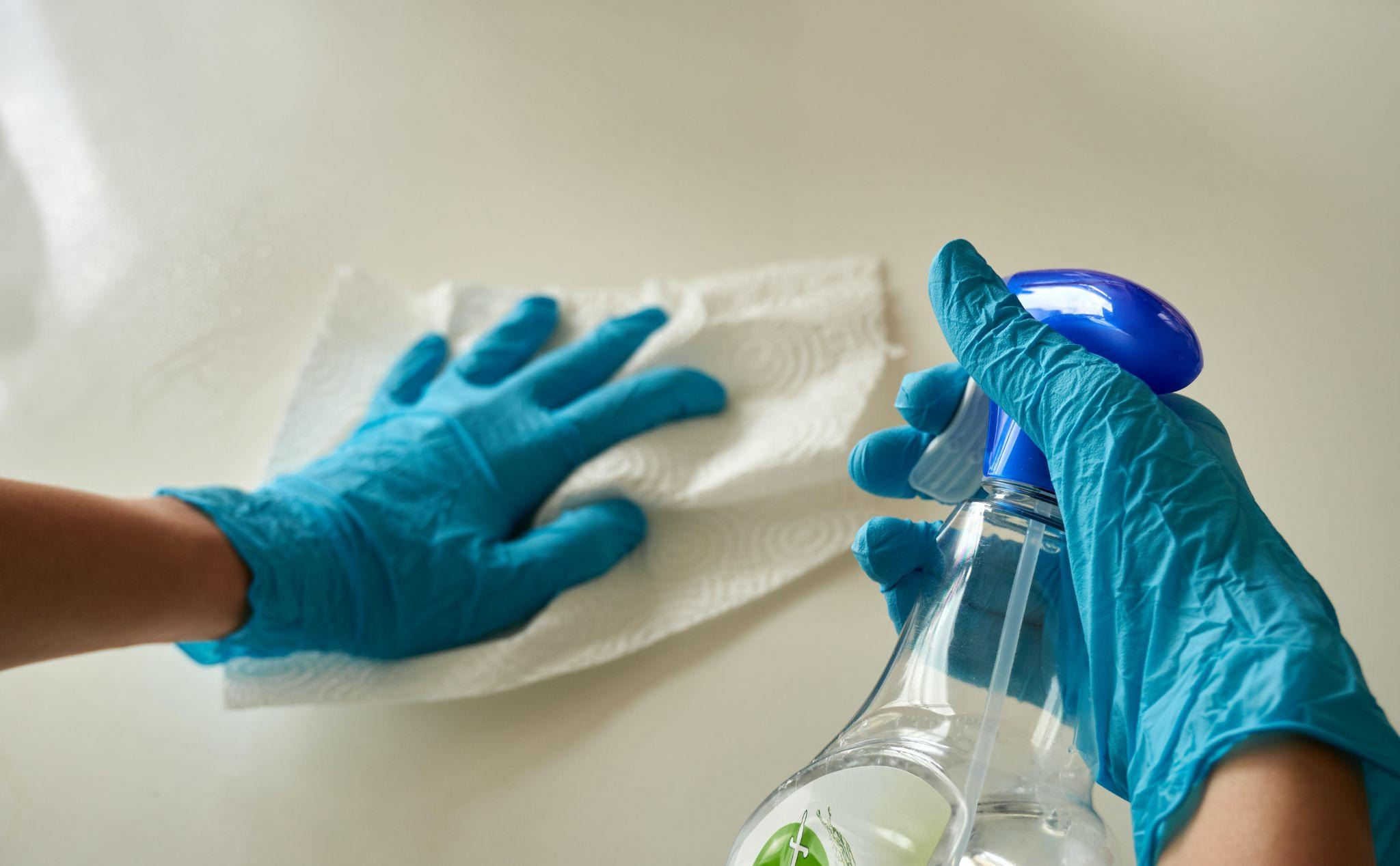 Cleaning spray and paper towel on a clean surface